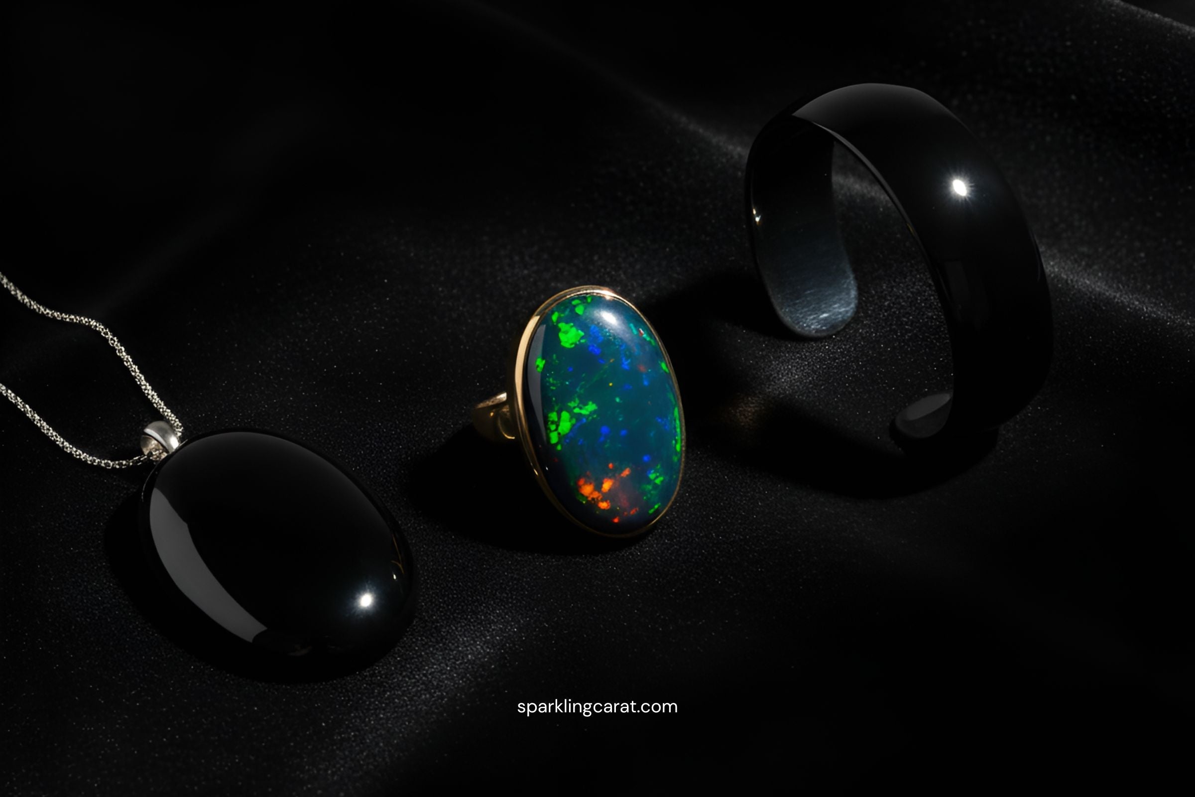 Onyx pendant, black opal ring, and black enamel cuff showcasing moody stones and dark gems trend for 2025.